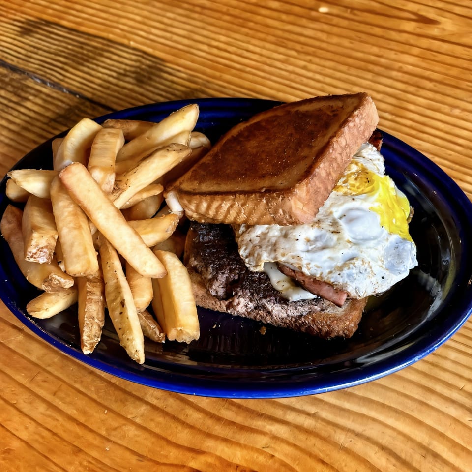 Big B Barbecue's open-faced sandwich with fried egg and fries on a blue plate.
