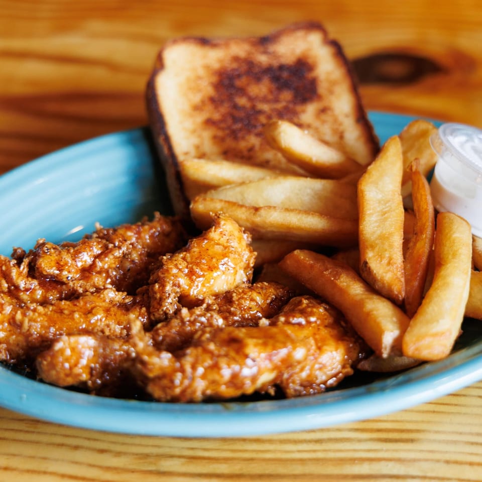 Big B Barbecue's chicken tenders with fries, Texas toast, and dipping sauce on a blue plate.